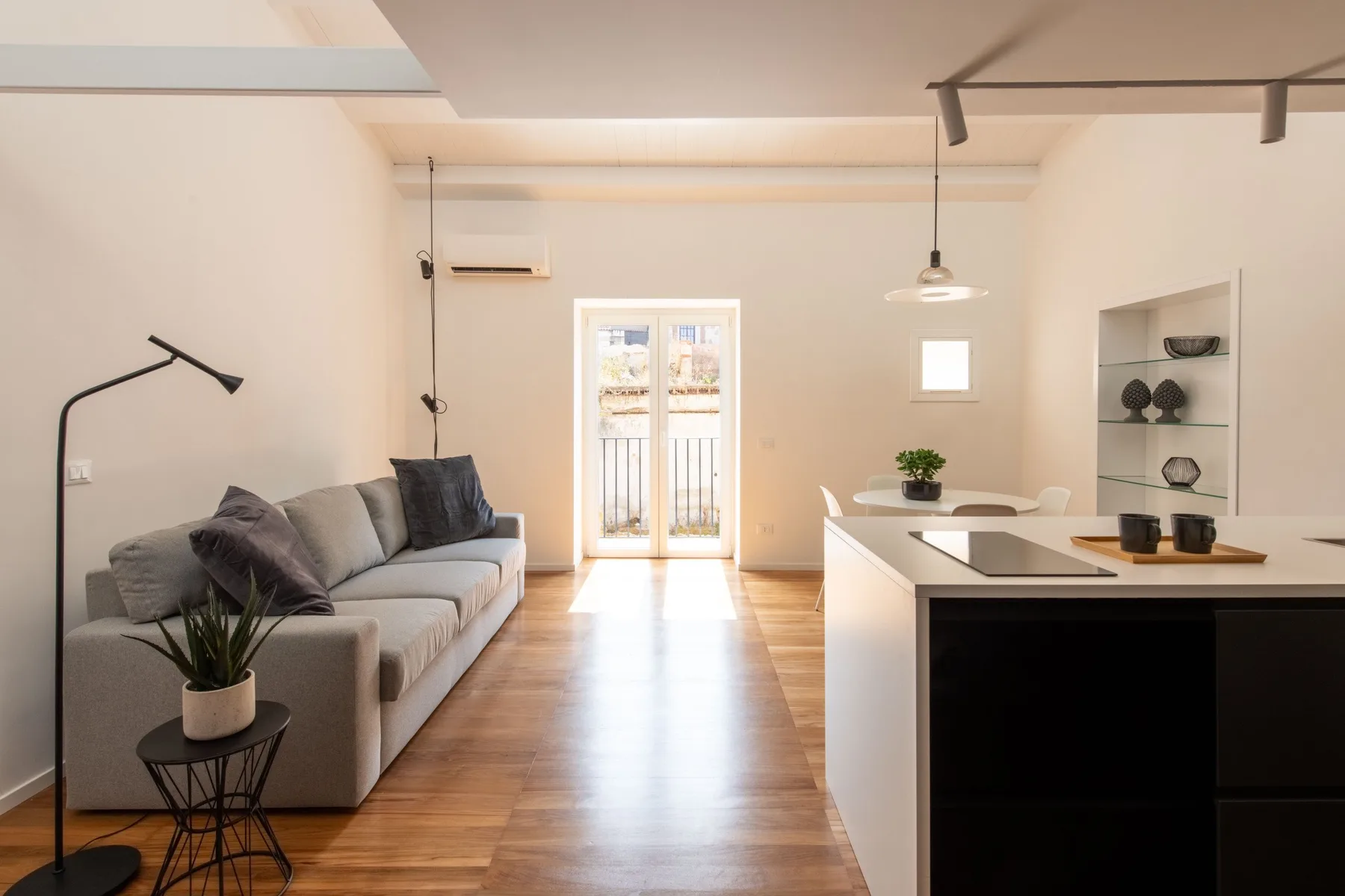 A bright open-plan living room and kitchen with seating and an island.