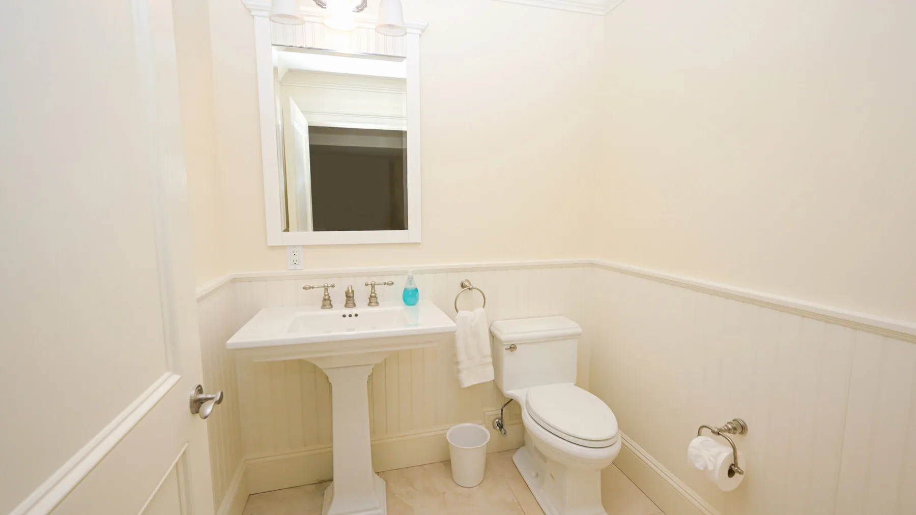 Un baño con lavabo, espejo e inodoro.