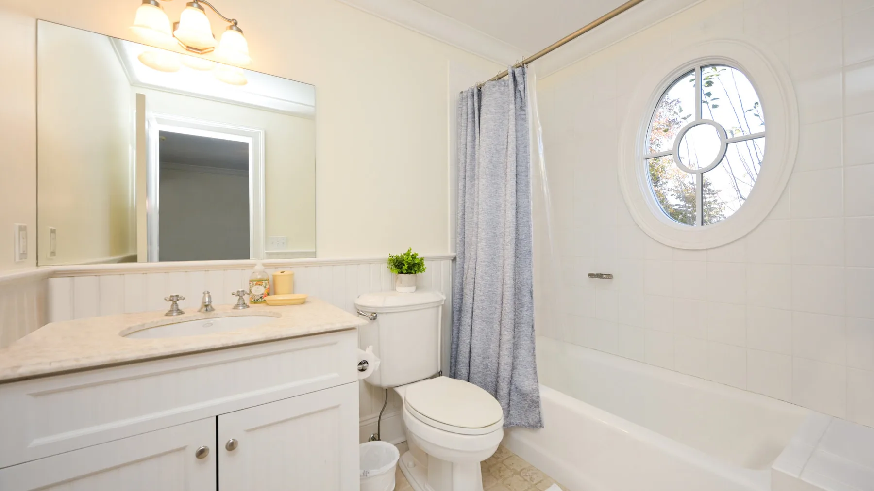 Un baño luminoso con lavabo, inodoro y bañera.