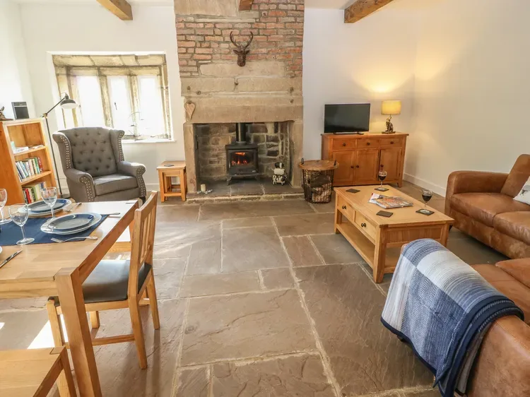 Una sala de estar con chimenea de piedra, asientos y una mesa de centro de madera.