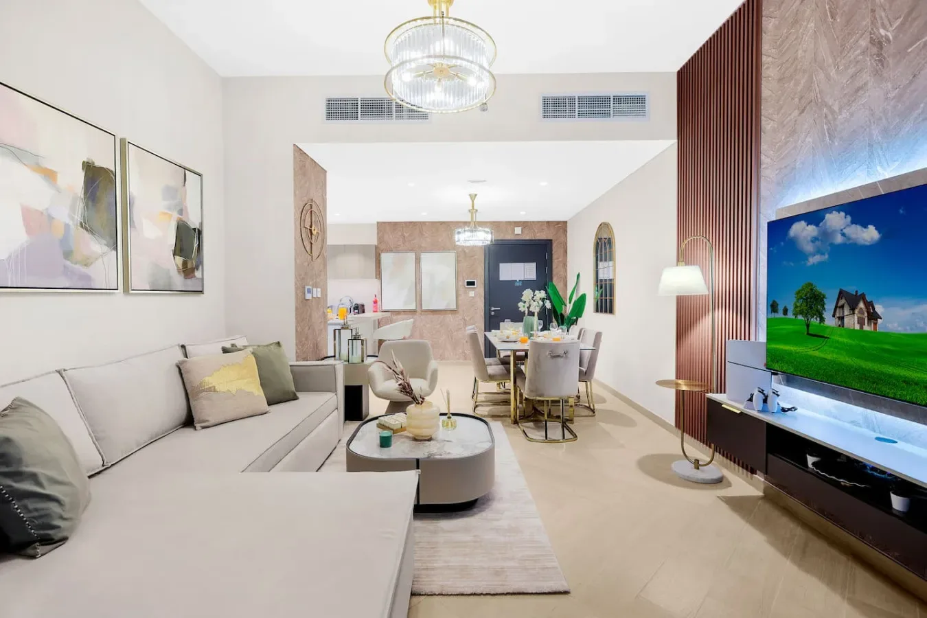 A bright living and dining area with seating, a table, and a television.