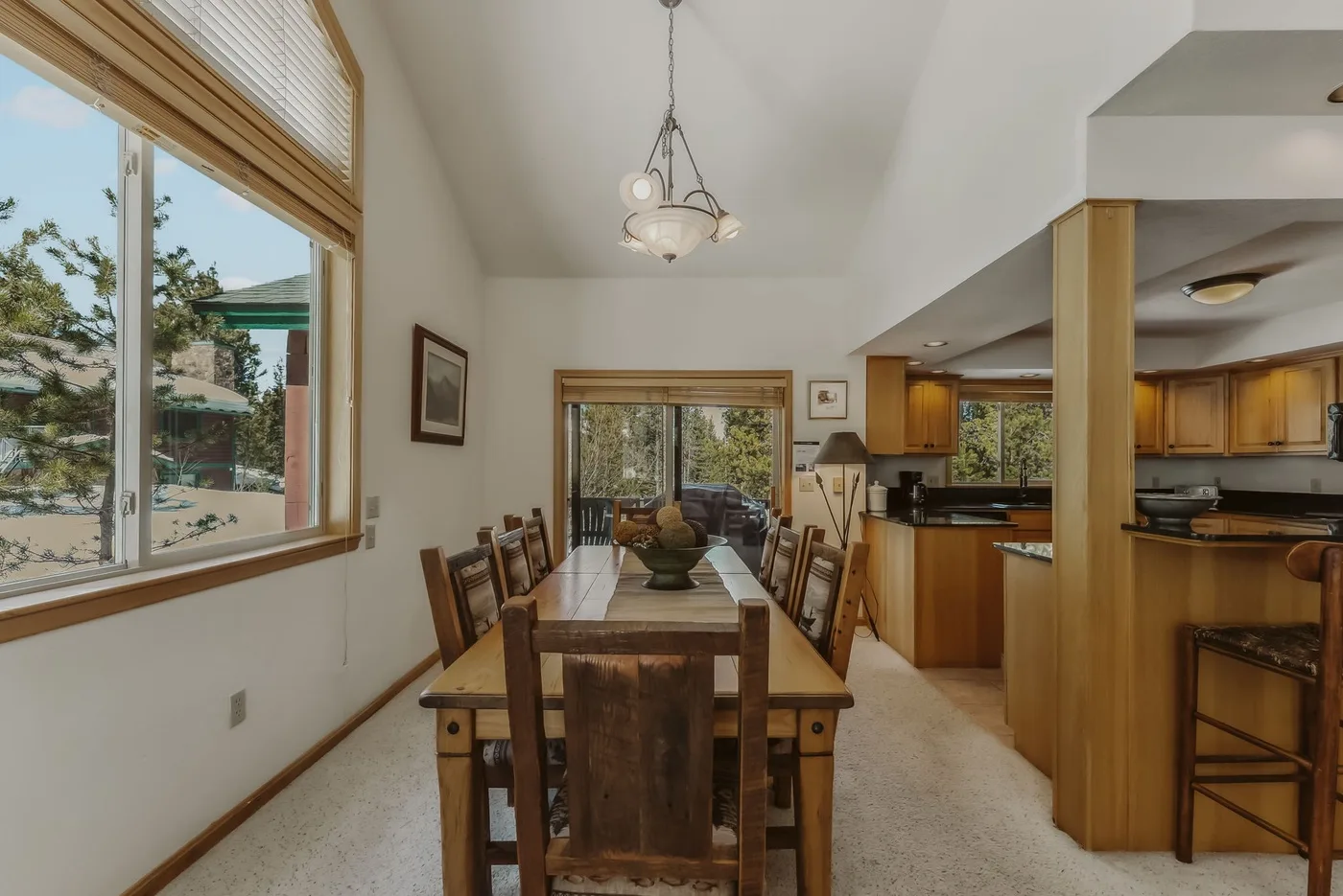 A dining area with a wooden table beside an open kitchen.