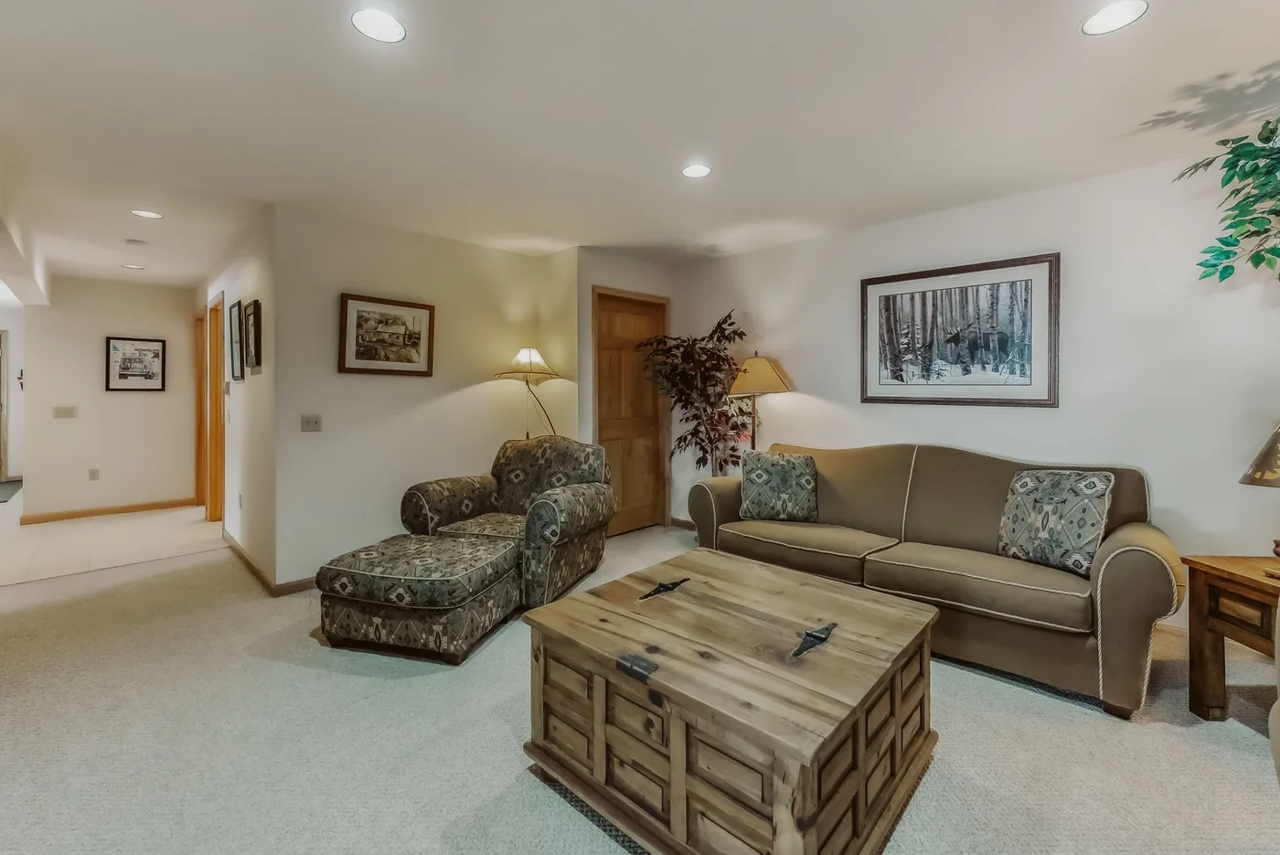 A living room with seating arranged around a wooden coffee table.