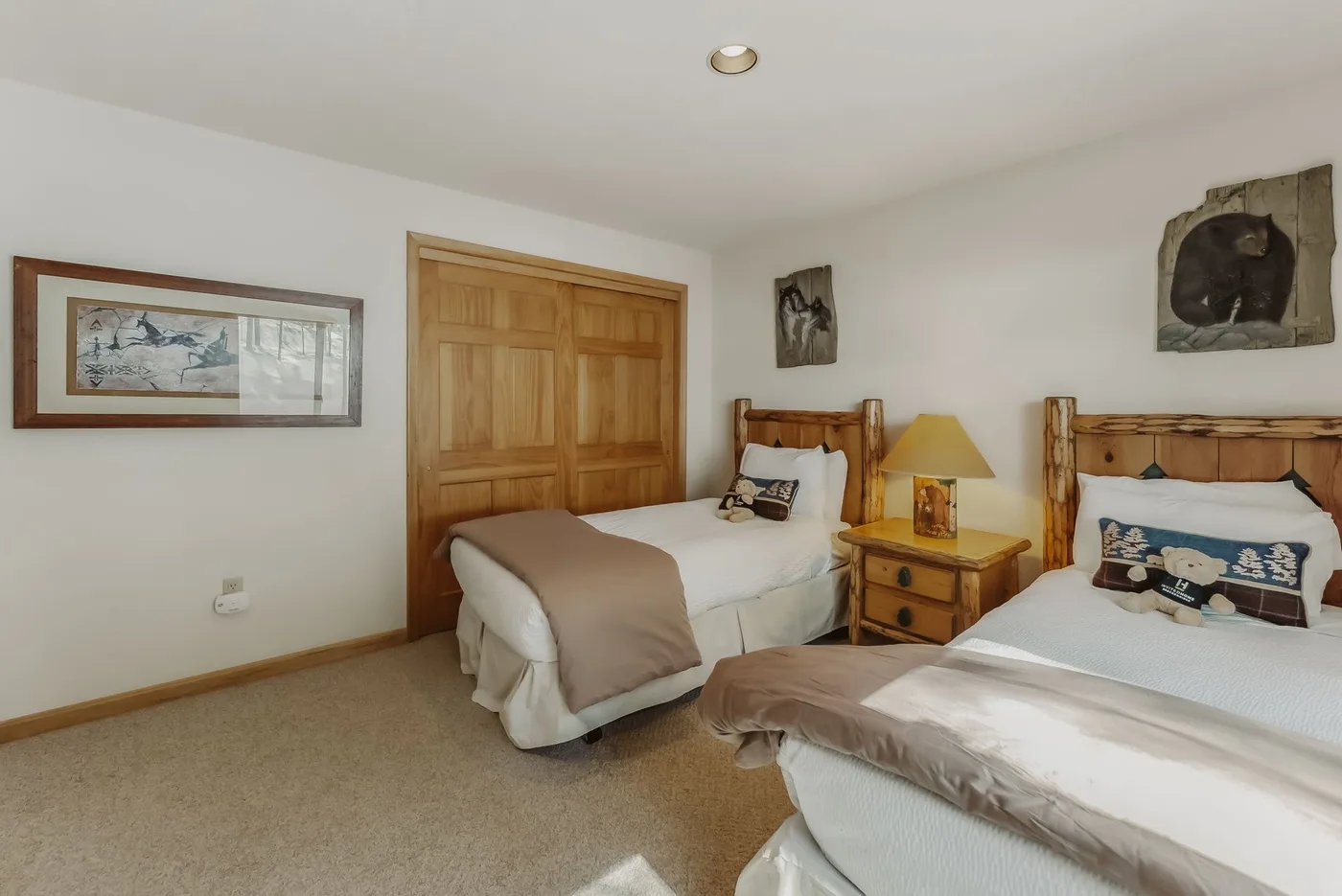 Bedroom with two beds, wooden headboards, and a nightstand between them.