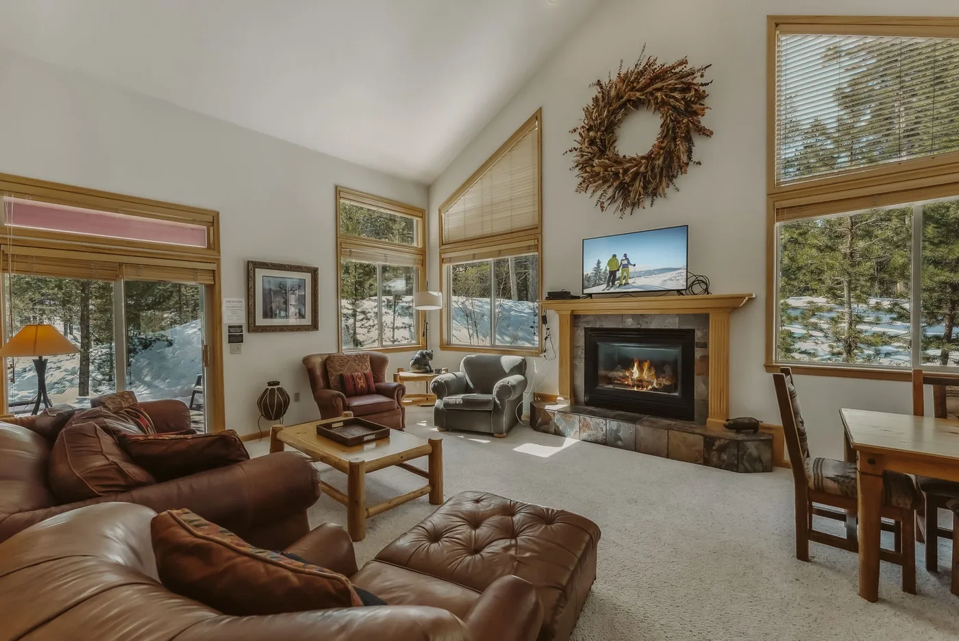 A living room with seating, a fireplace, and large windows.
