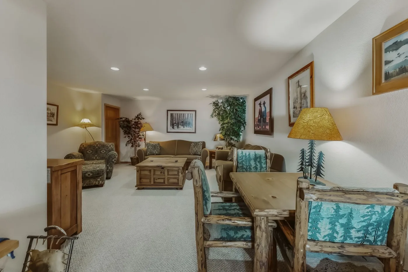 A furnished living and dining area with wooden tables and patterned seating.
