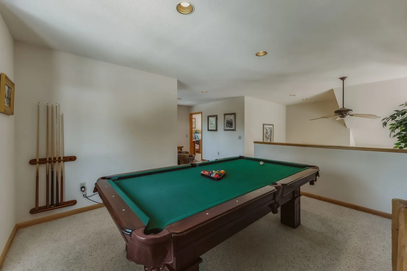 A billiards table fills a carpeted game room.