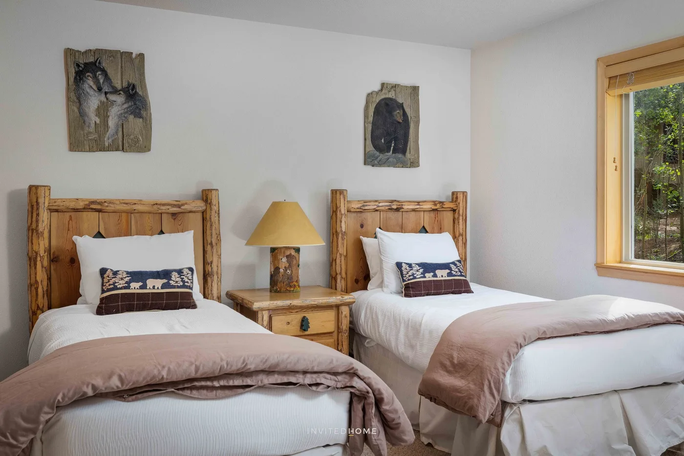 A twin bedroom with two wooden beds and a bedside table between them.