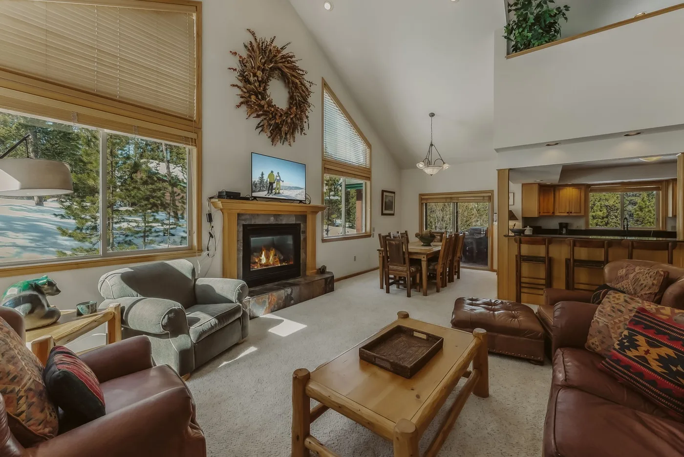 A spacious living room with seating, a fireplace, and an adjoining dining area.