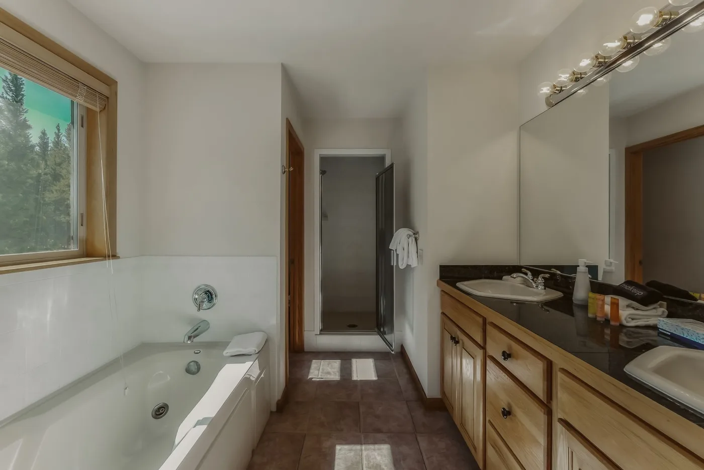 A bathroom with a bathtub, a vanity, and a glass shower.