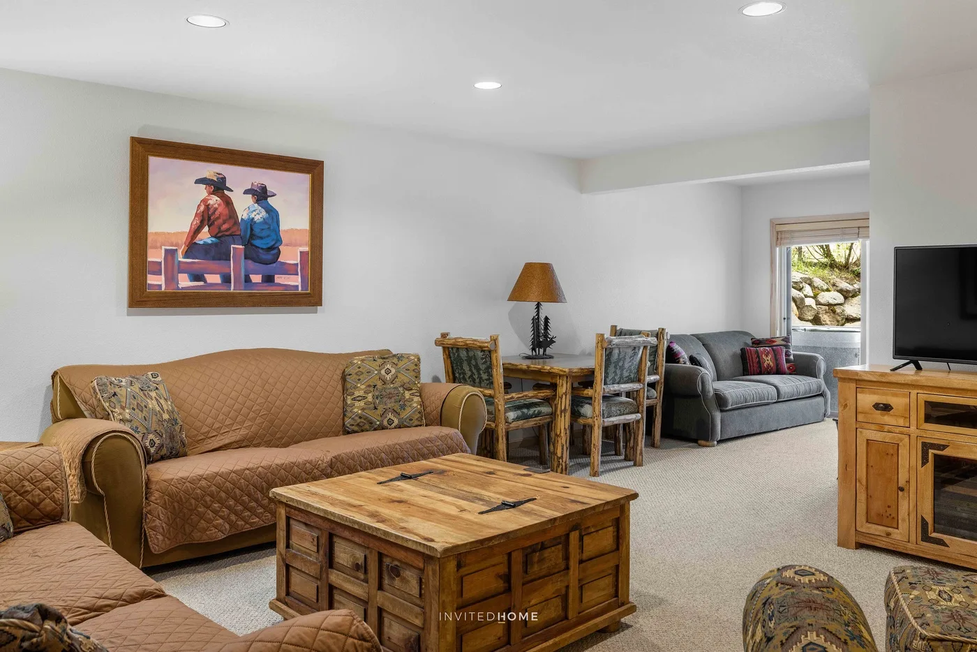 A living room with seating, a wooden coffee table, and a dining area.