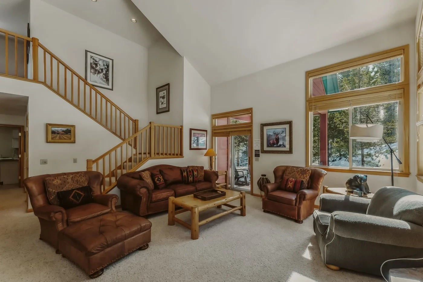 A living room with seating, a coffee table, and a staircase.