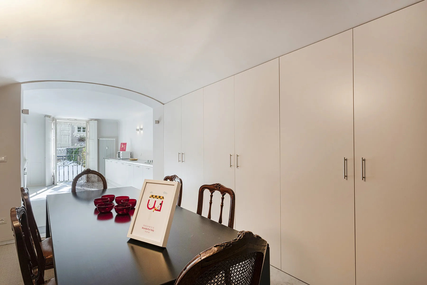 Comedor con una mesa oscura y armarios empotrados junto a la pared.
