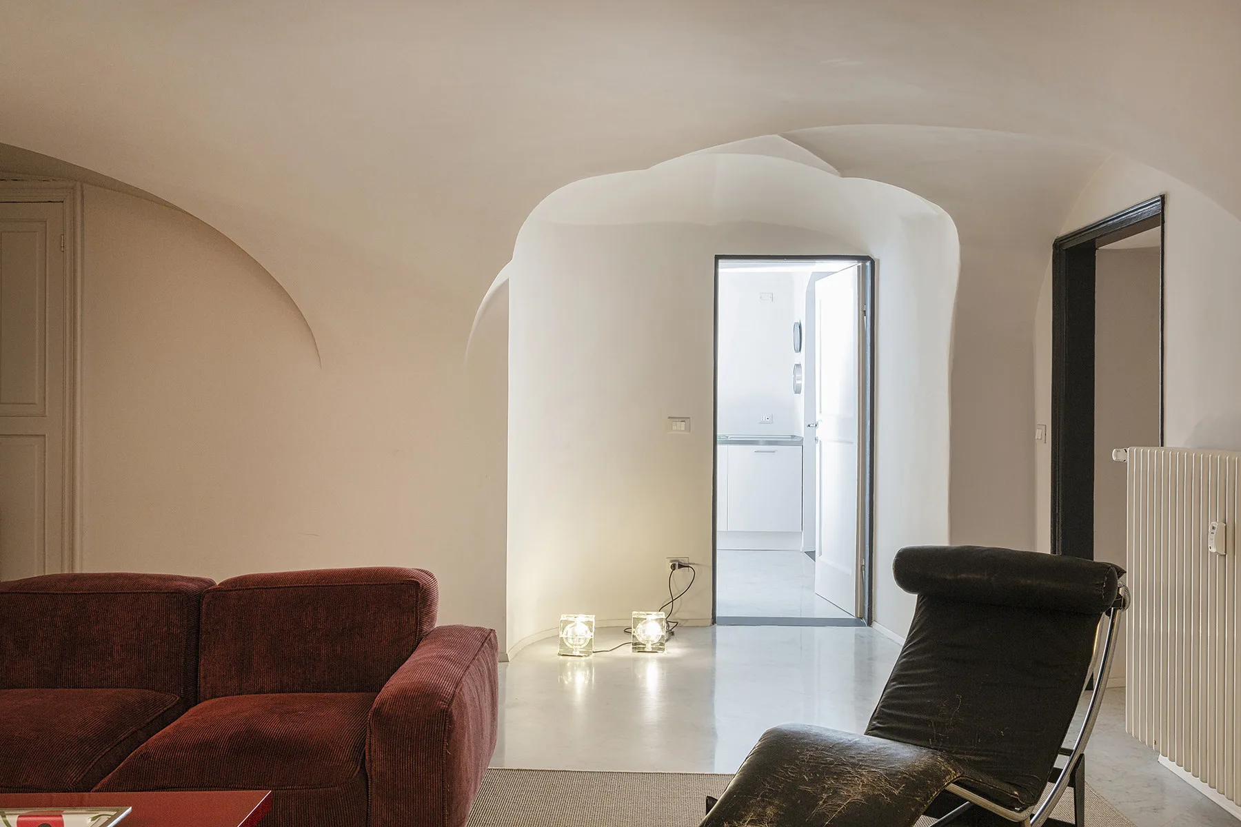 Una sala de estar con asientos dispuestos frente a una puerta abierta.