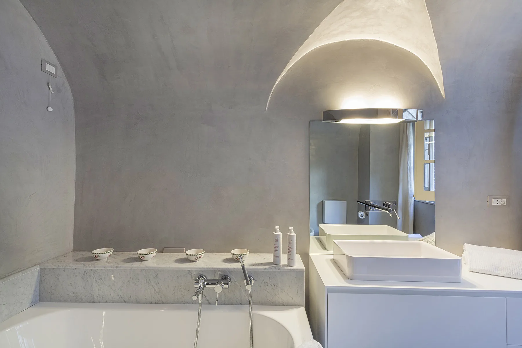 Un baño con bañera, lavabo y un espejo grande.