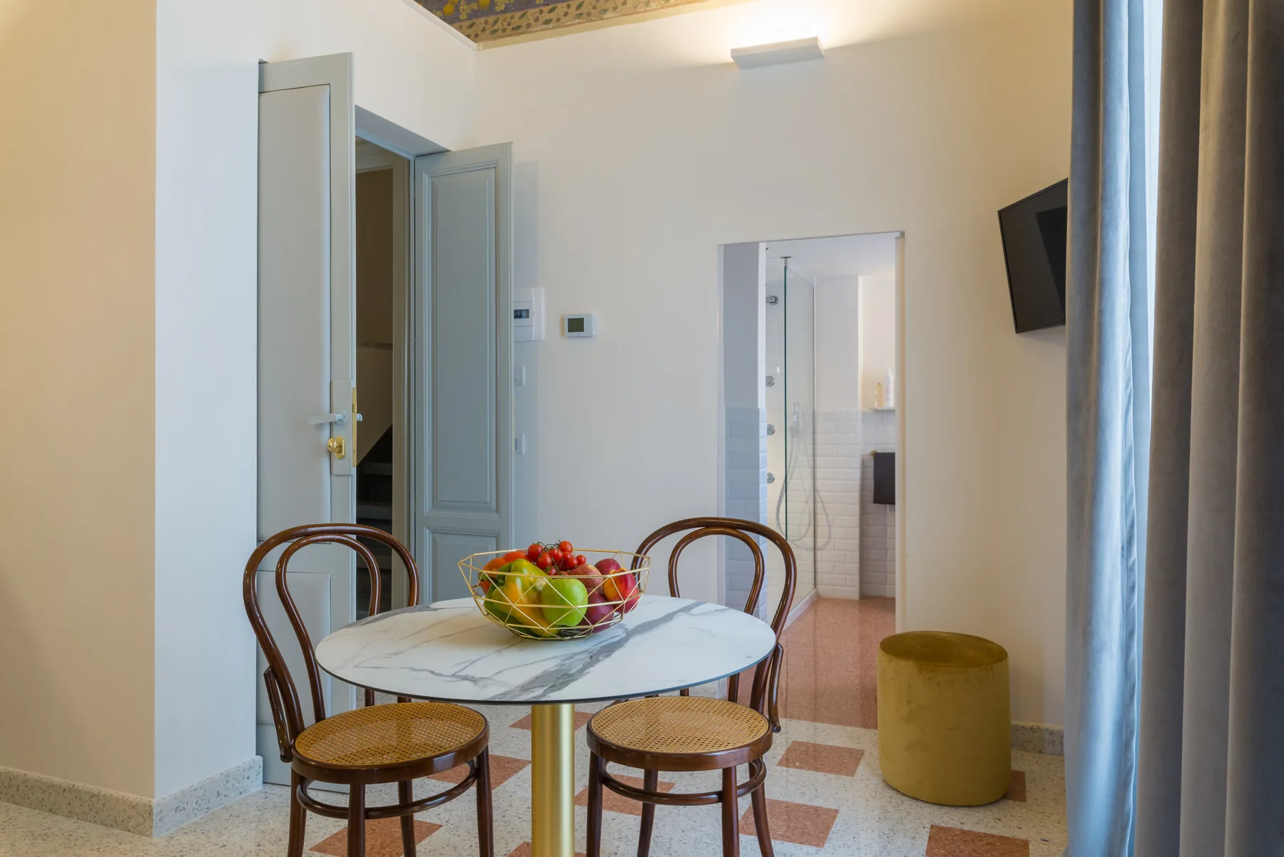 A dining area with a round table and chairs beside an open doorway.