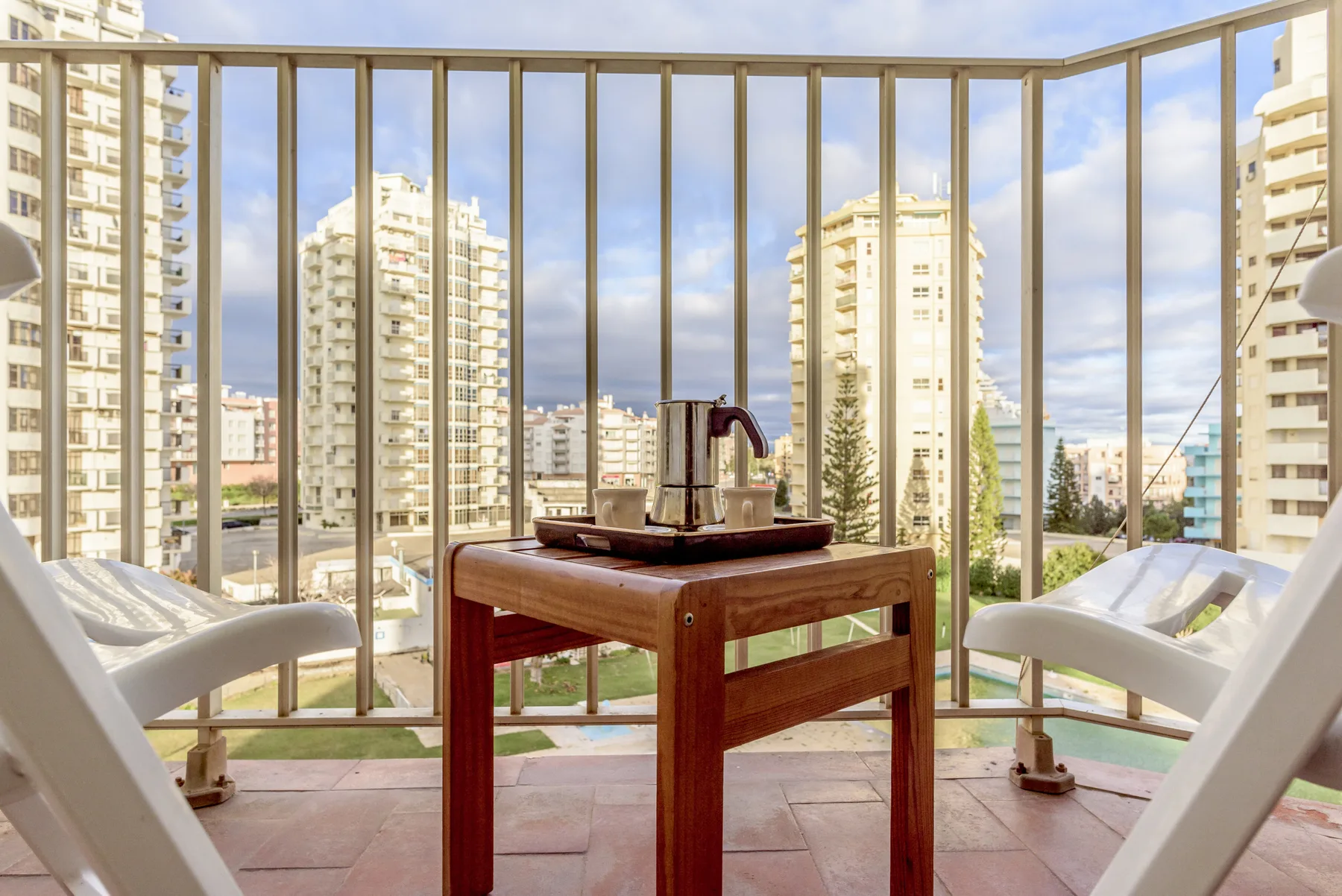 Una zona de descanso en el balcón tiene vistas a edificios altos cercanos.