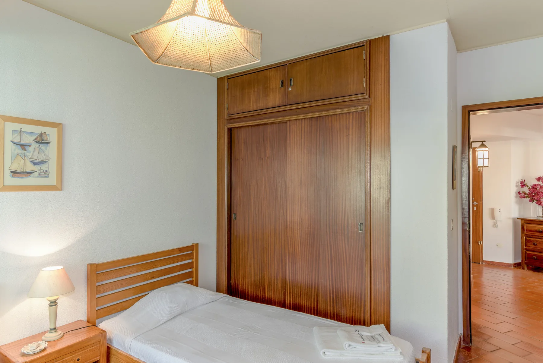 Un dormitorio con una cama, una mesita de noche y un armario empotrado de madera.