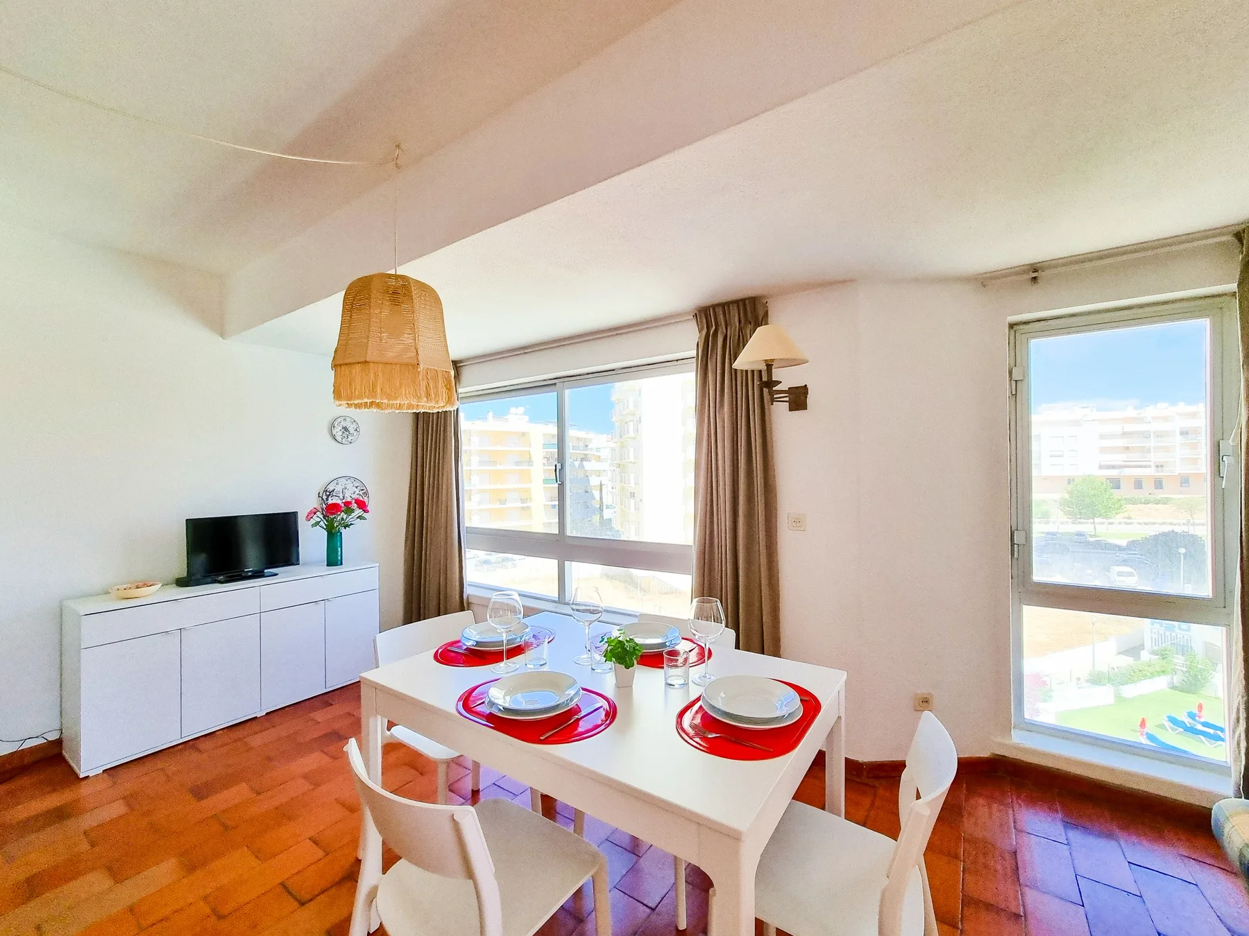 Comedor con una mesa blanca y grandes ventanales.