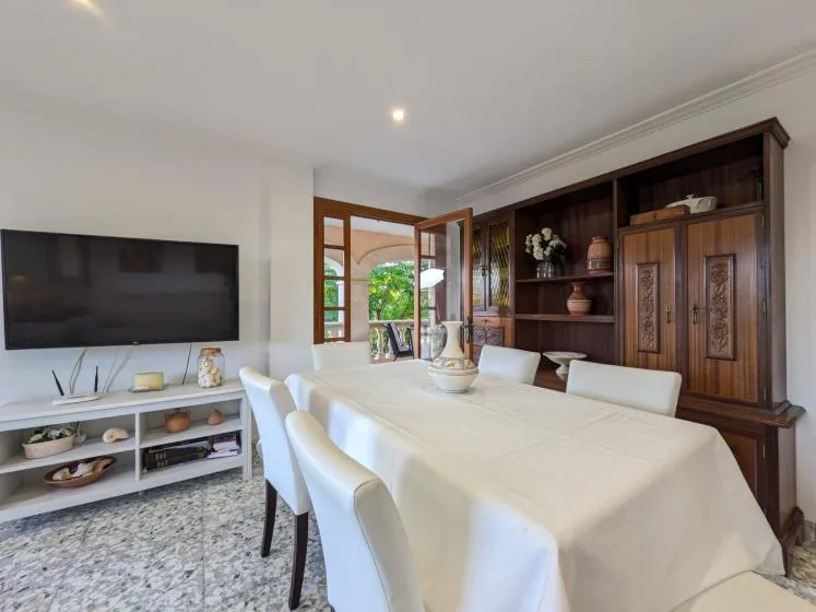 Un comedor con una mesa larga frente a un mueble de madera.