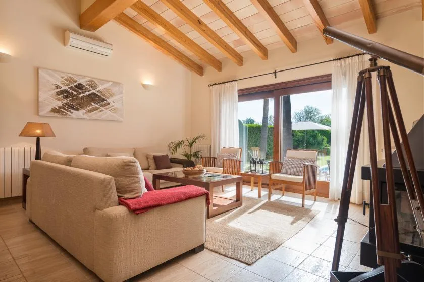 A bright living room with seating, a coffee table, and large glass doors.