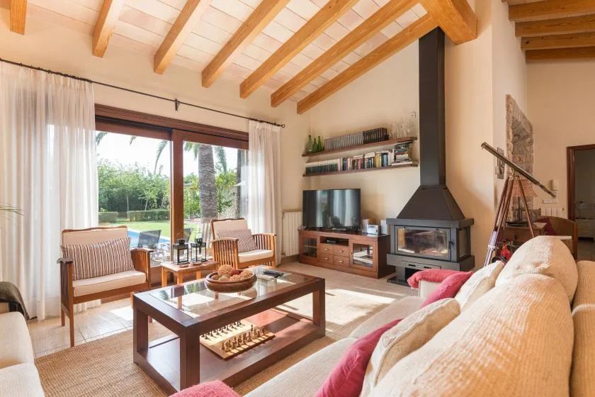 A bright living room with seating, a coffee table, and a fireplace.