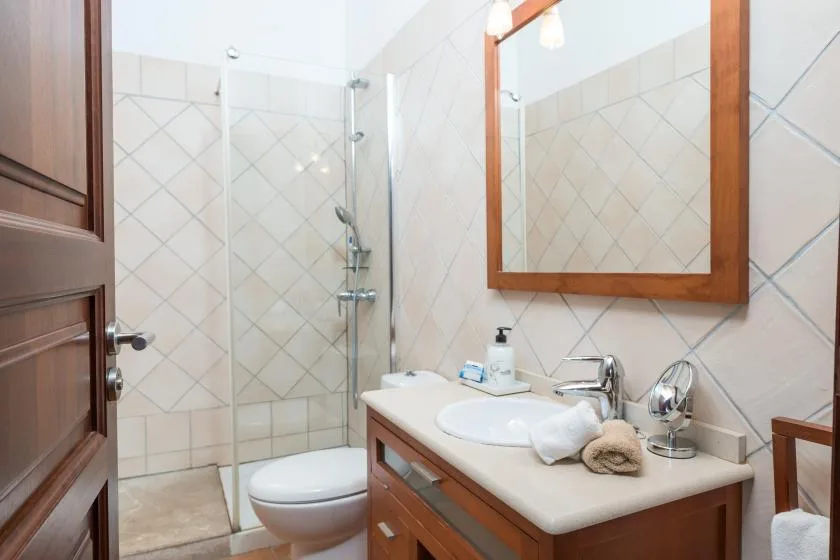 A tiled bathroom with a shower, toilet, and sink vanity.