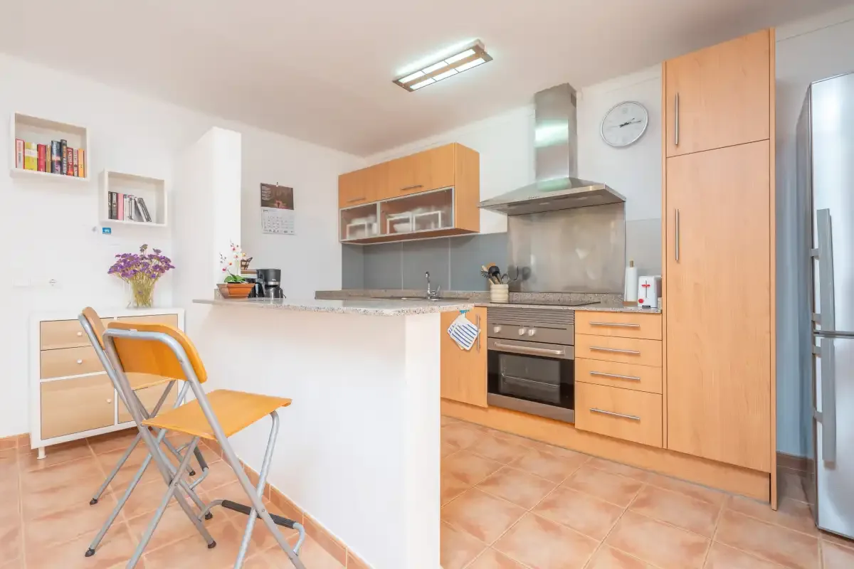 Una cocina luminosa con armarios de madera y una barra.
