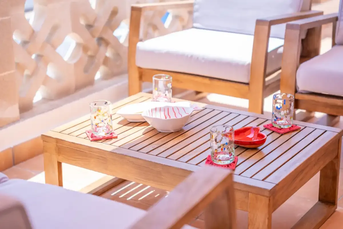 Una zona de estar con una mesa de madera y vasos y un cuenco.
