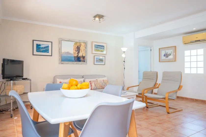 Una sala luminosa con mesa de comedor, asientos y cuadros en la pared.