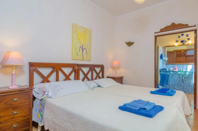 Un dormitorio con una cama grande, cabecero de madera y lámparas de noche a juego.