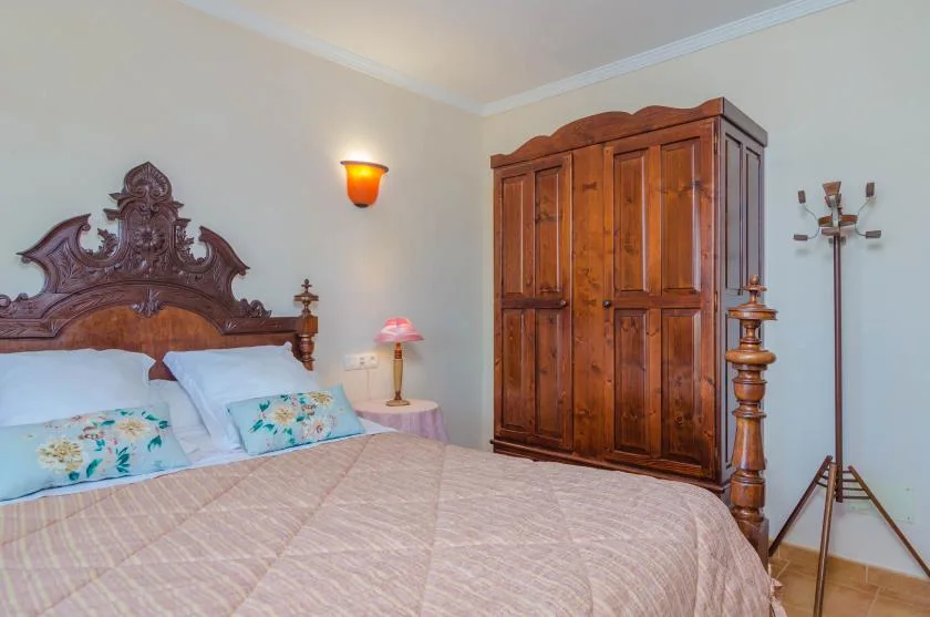 Un dormitorio con una cama grande y un armario de madera.