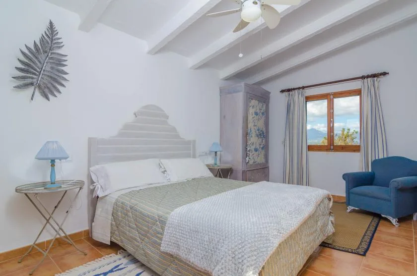 Un dormitorio con una cama grande, mesitas de noche y una ventana.