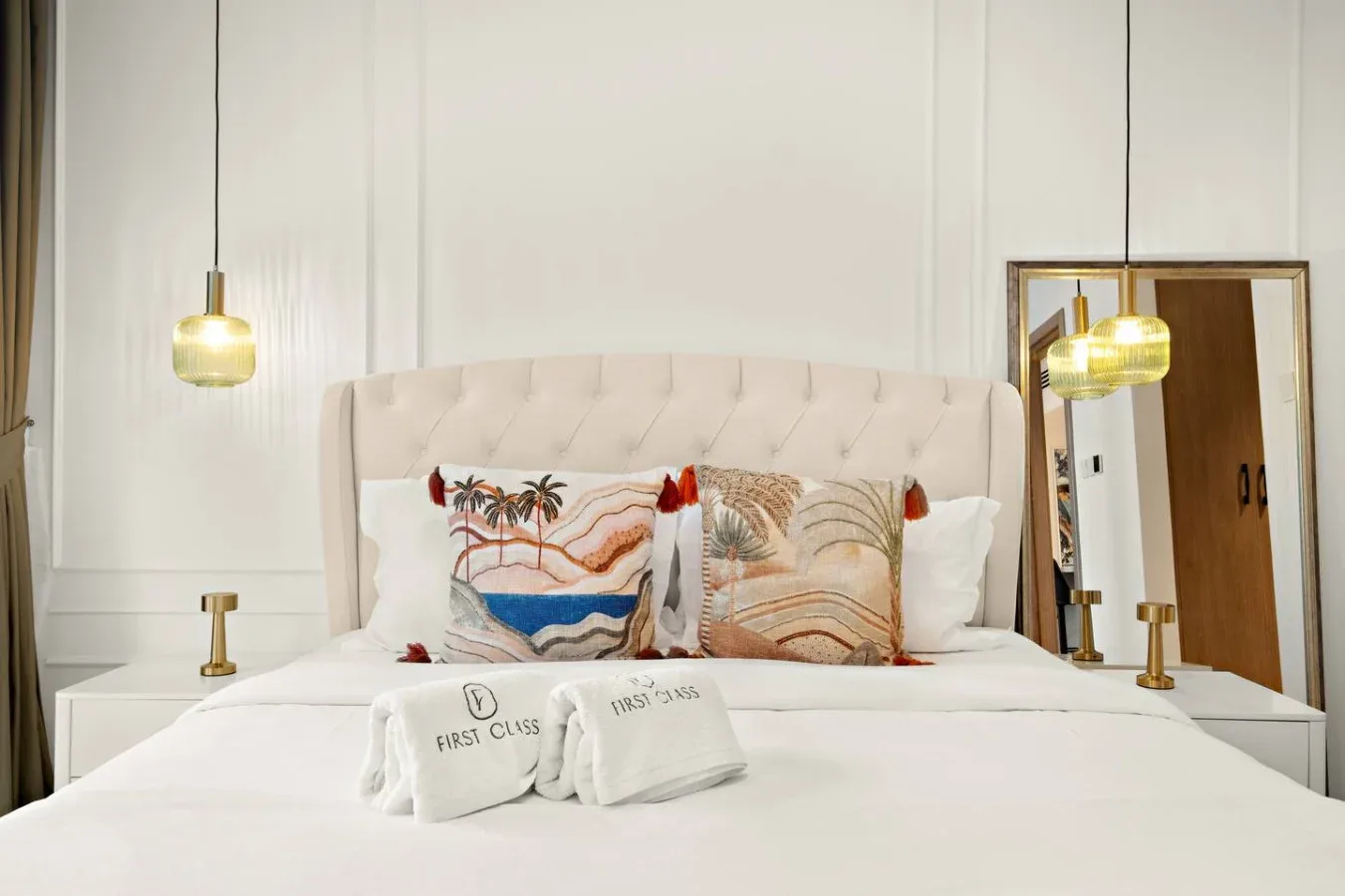 Un dormitorio con una cama bien tendida y cojines decorativos.