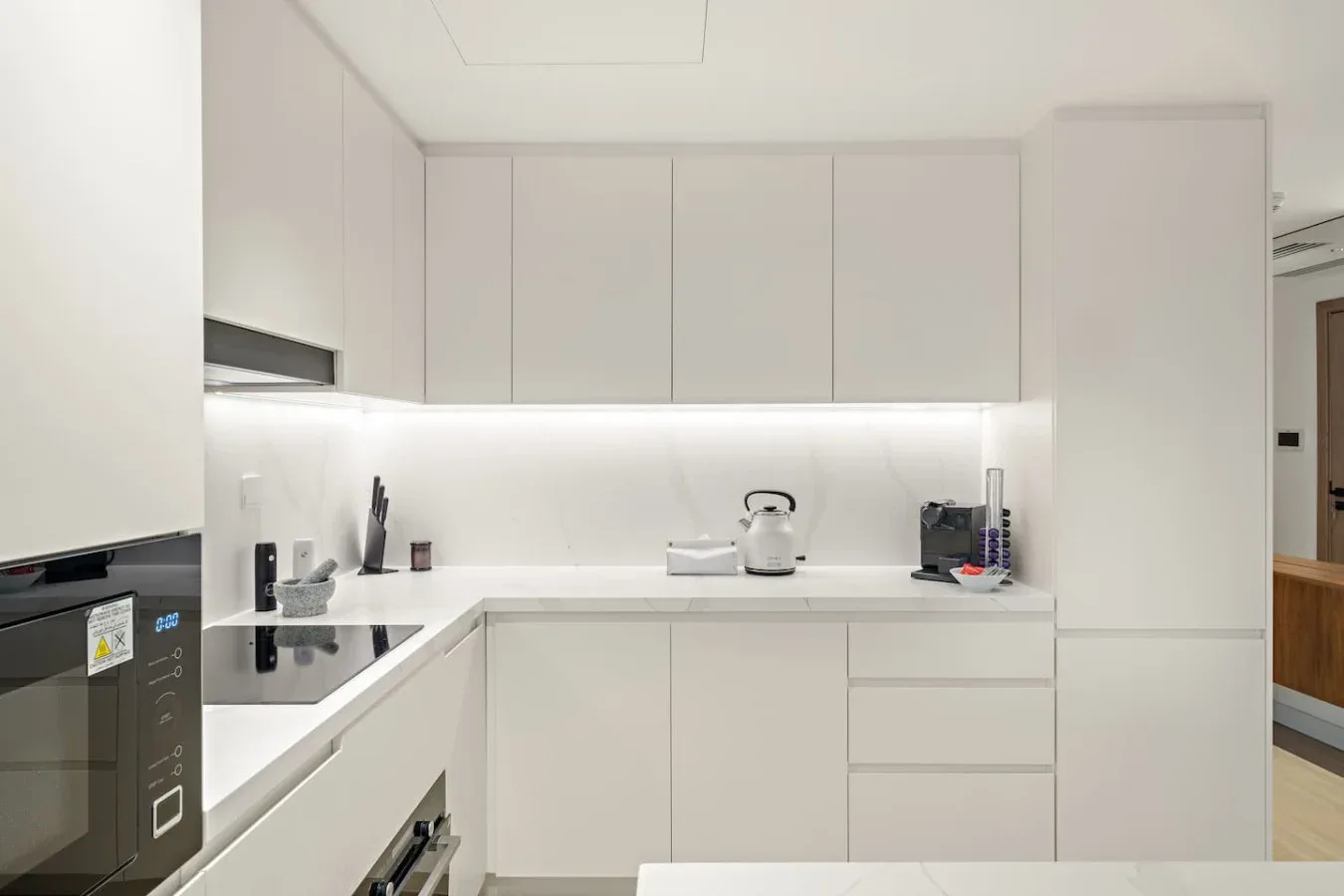 Una cocina moderna con gabinetes blancos y una encimera.