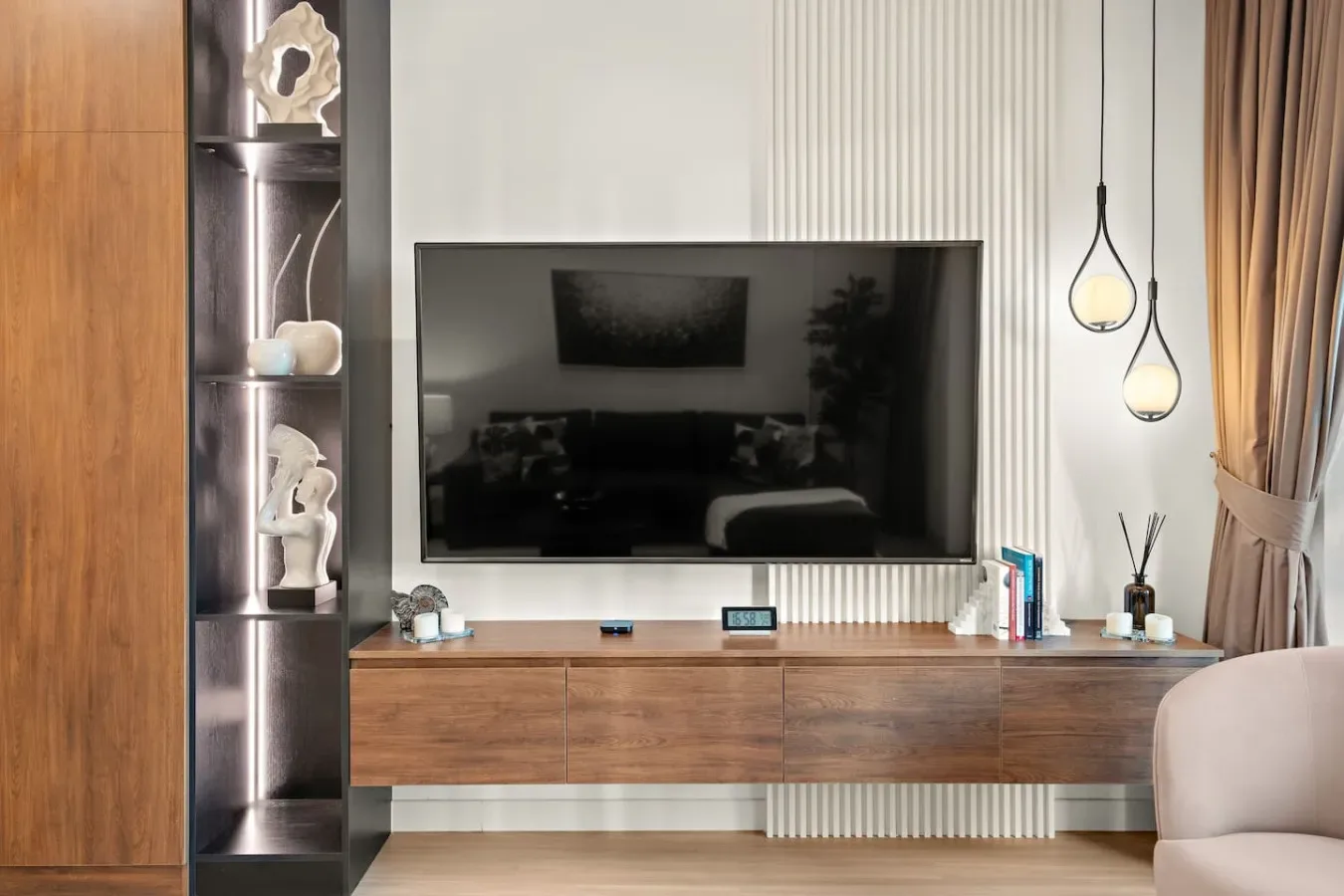 Una pared multimedia en una sala de estar, con un televisor sobre un mueble de madera.