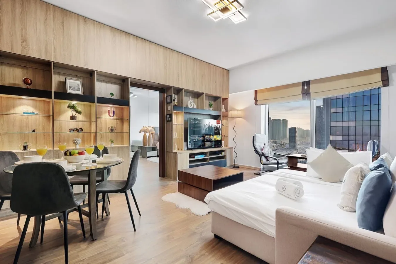 Un dormitorio y una zona de comedor comparten un espacio abierto junto a grandes ventanas.