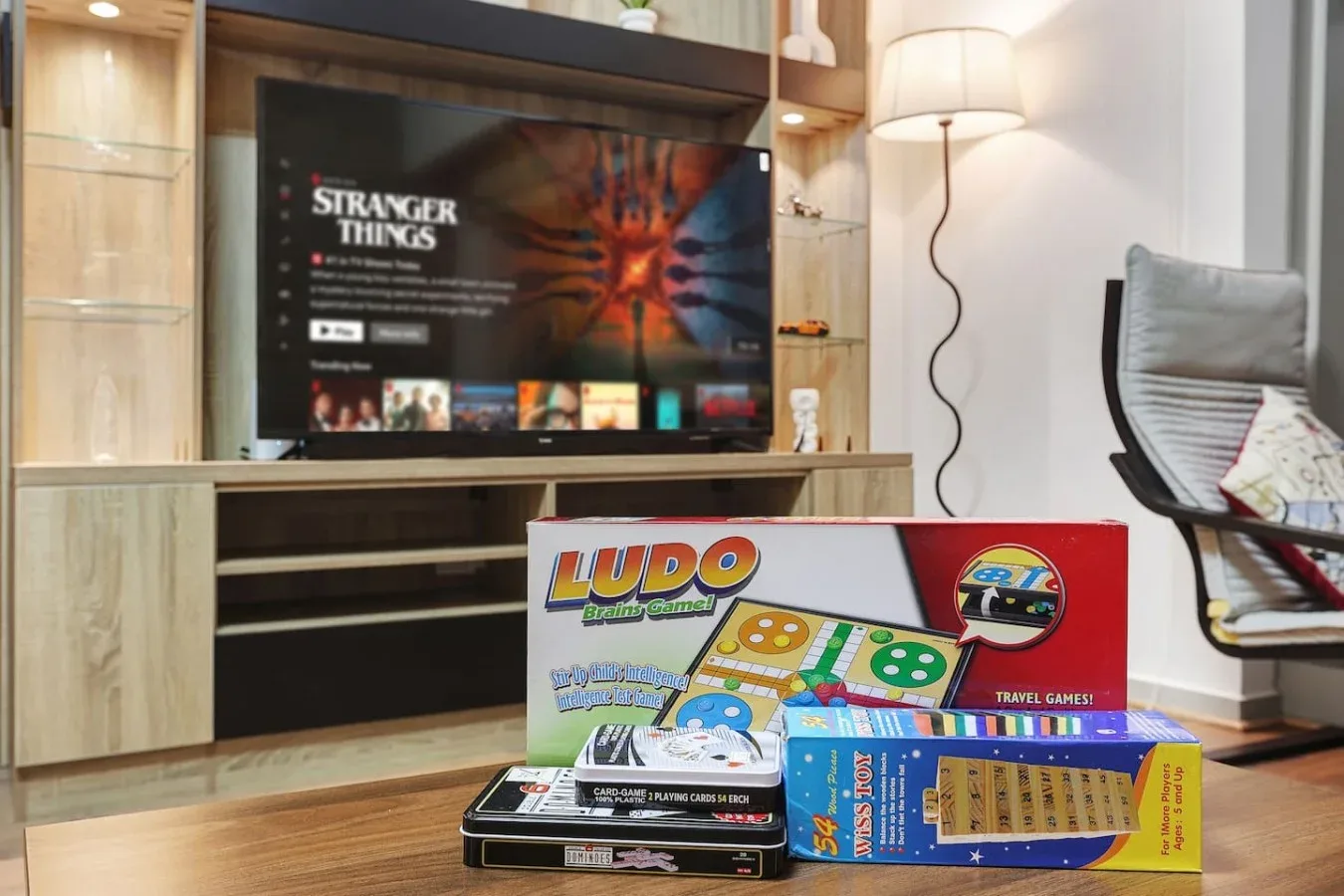 Una zona de entretenimiento en una sala de estar, con un televisor y juegos de mesa sobre una mesa baja.