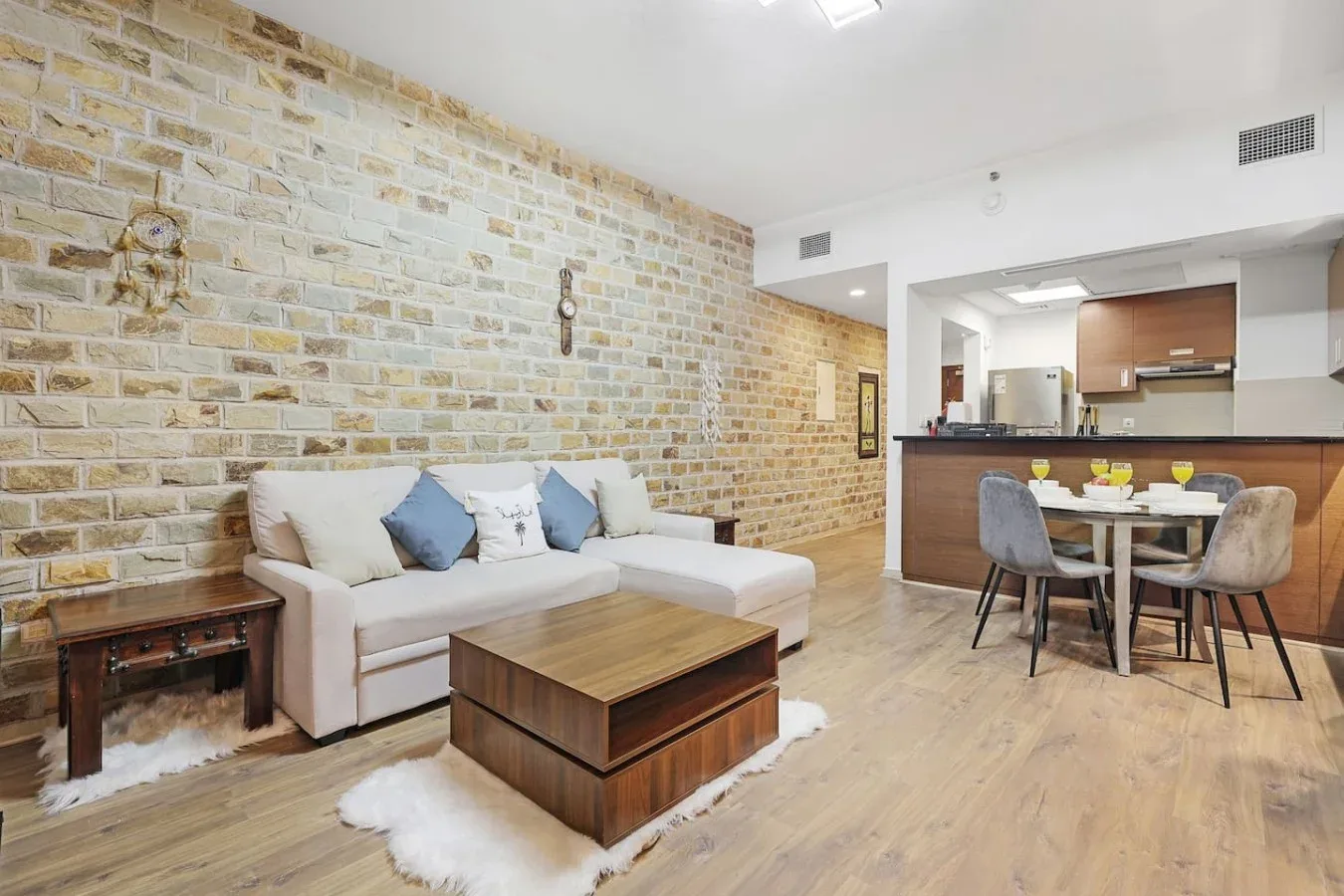 Sala de estar con asientos y una mesa de centro de madera junto al comedor.