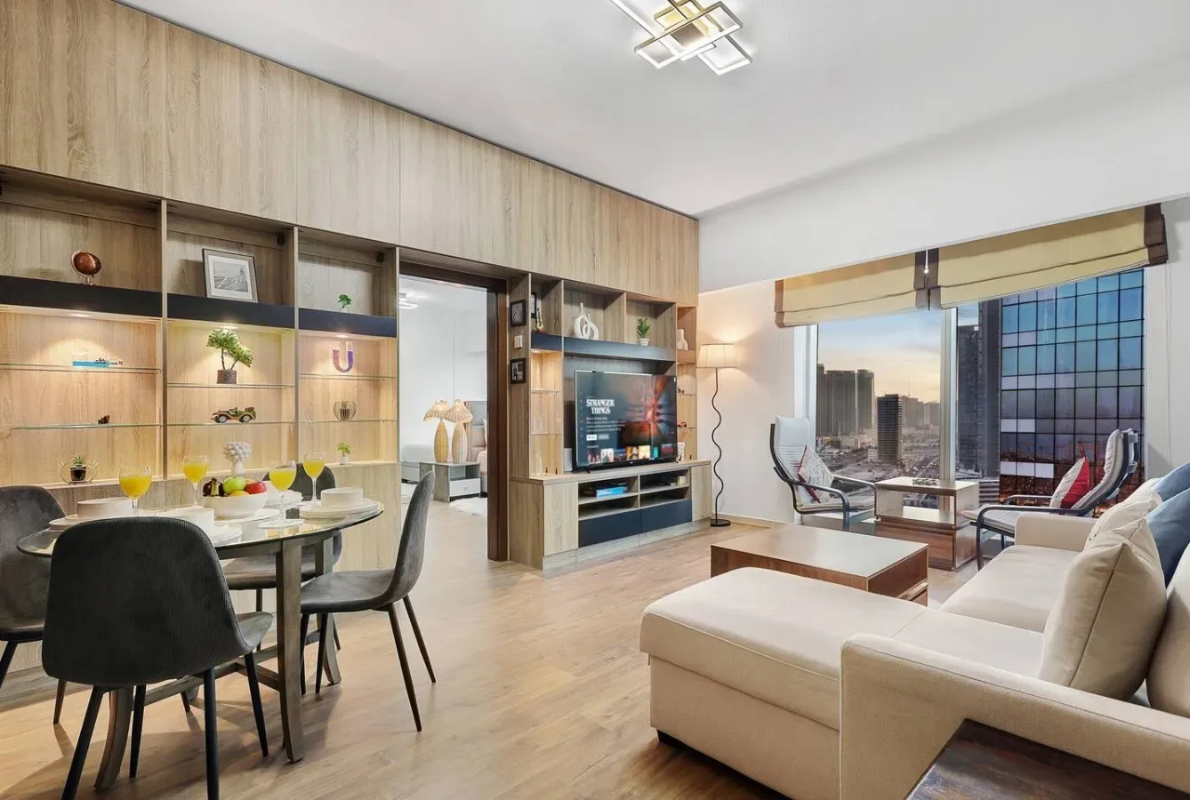 Una sala de estar y comedor moderna con amplias ventanas con vistas a edificios de la ciudad.