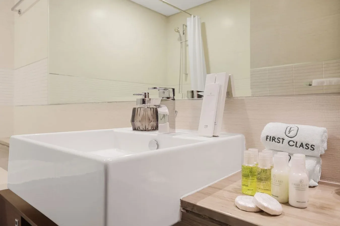 Un tocador de baño con un lavabo blanco grande y artículos de aseo sobre la encimera.