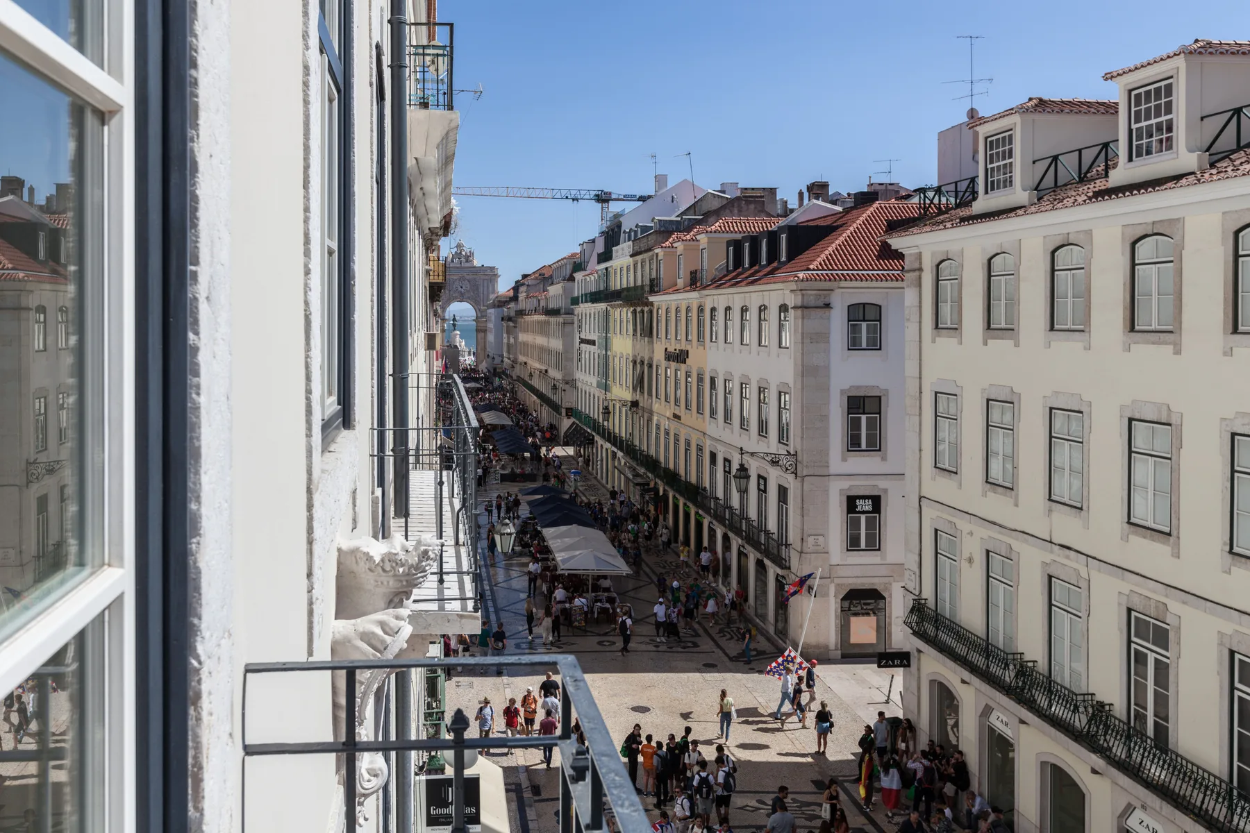 Una calle de la ciudad flanqueada por edificios, vista desde arriba.