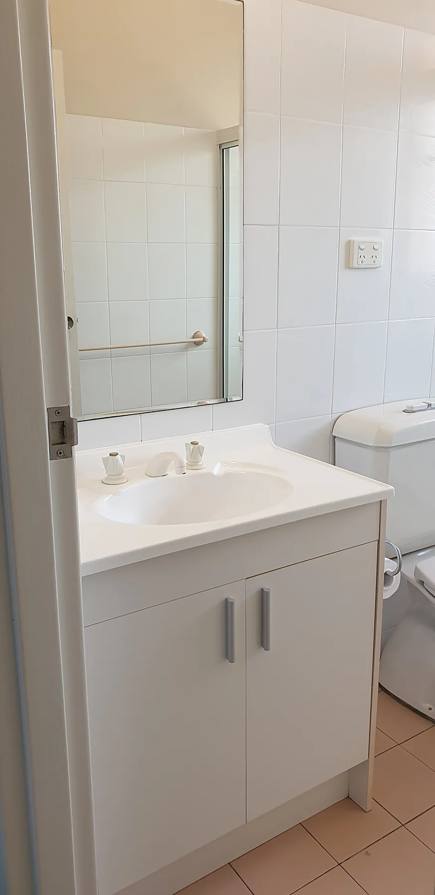 Un baño con azulejos, lavabo, espejo e inodoro.