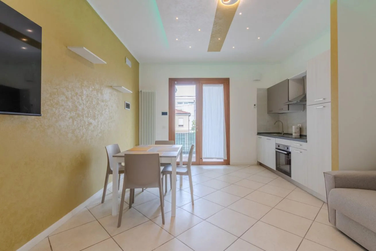A bright kitchen and dining area with a table beside the window.