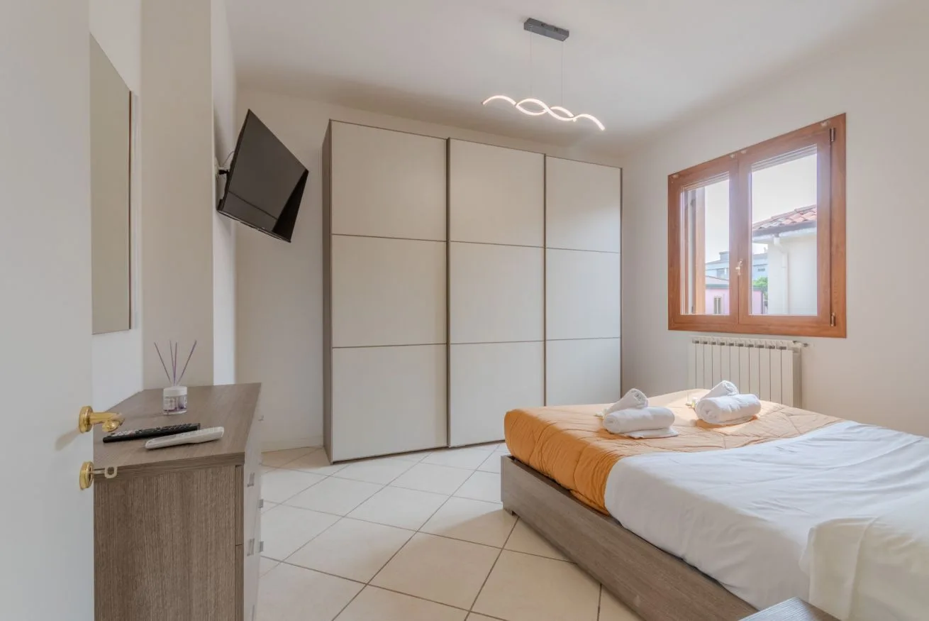 A bedroom with a double bed and large built-in wardrobe.