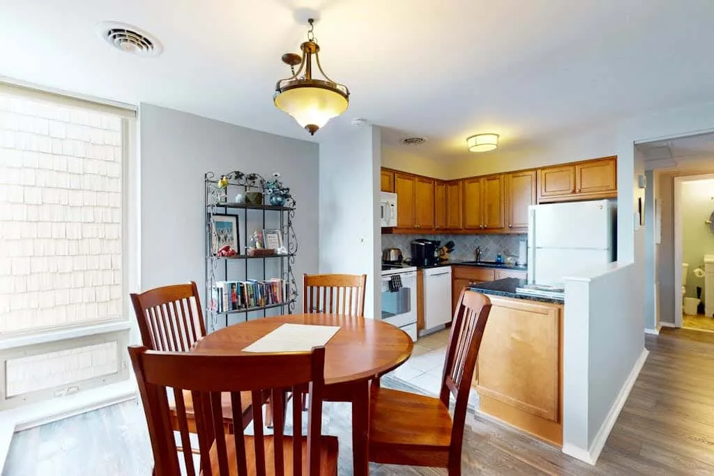 A dining area with a round wooden table beside a kitchen.