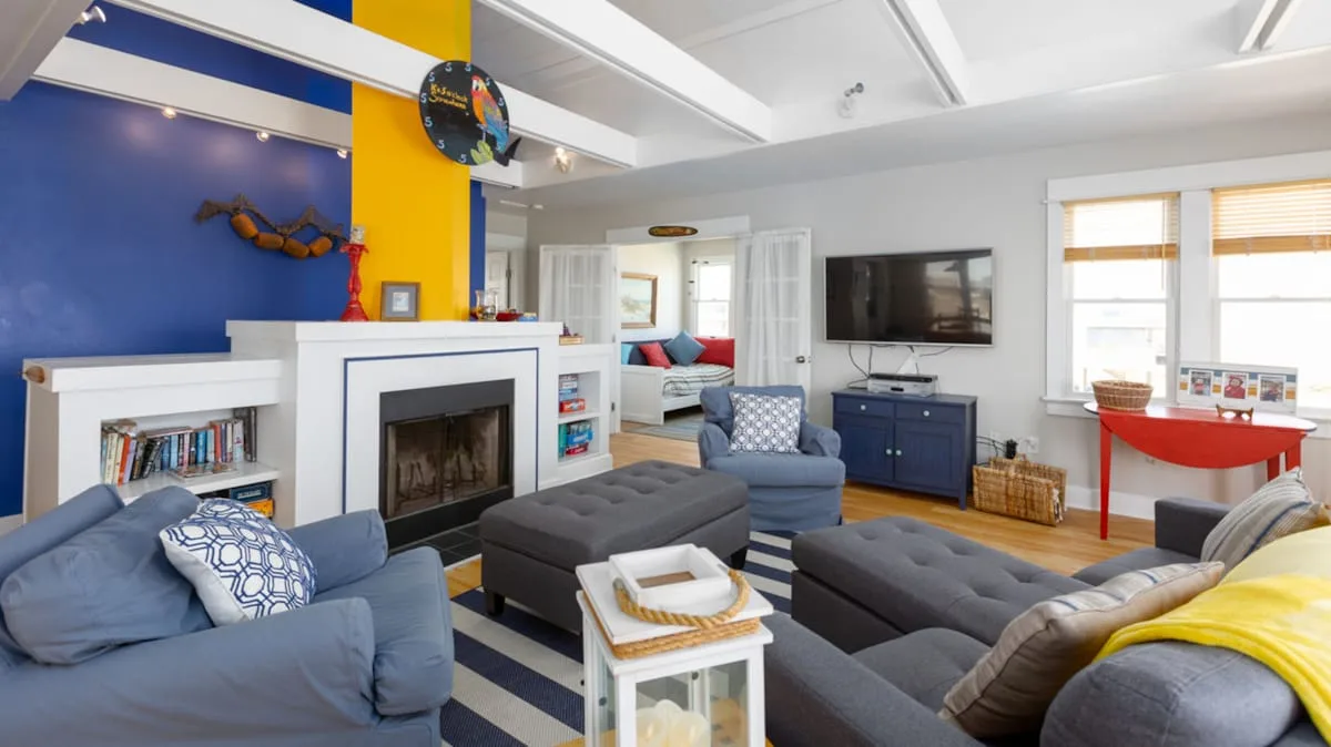 A colorful living room with seating, a fireplace, and a television.
