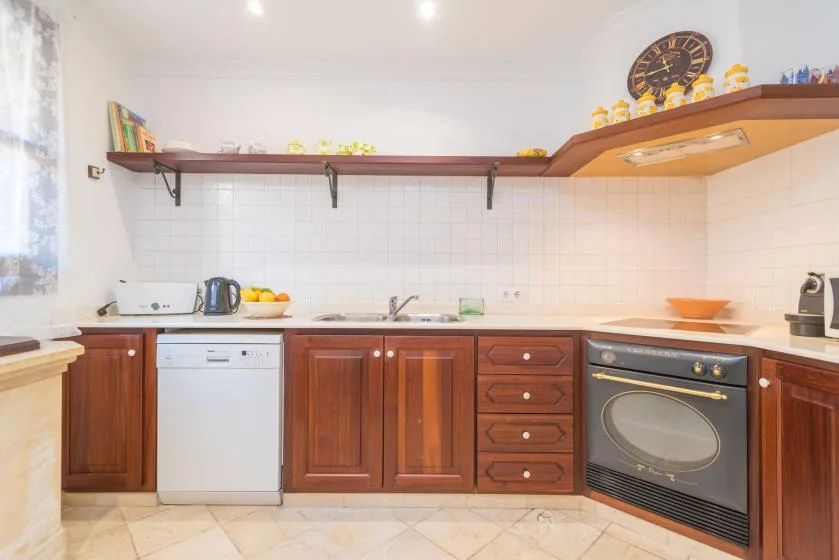 A bright kitchen with wooden cabinets, a tiled backsplash, and countertop appliances.