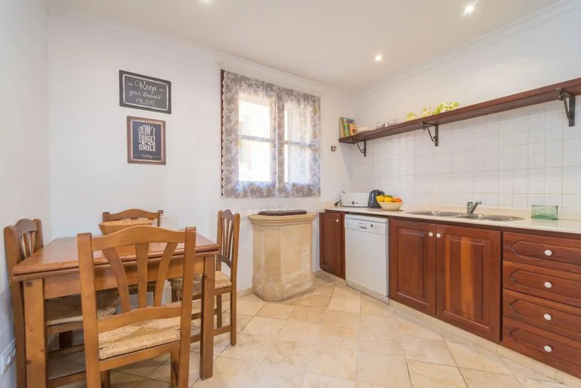 A kitchen and dining area with wooden seating and a tiled counter wall.