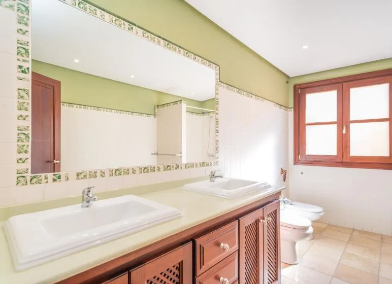 A bathroom with a long vanity, two sinks, and a large wall mirror.